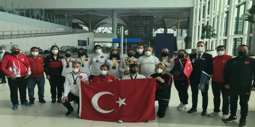 Dünya şampiyonu özel sporcular havalimanında çiçeklerle karşılandı