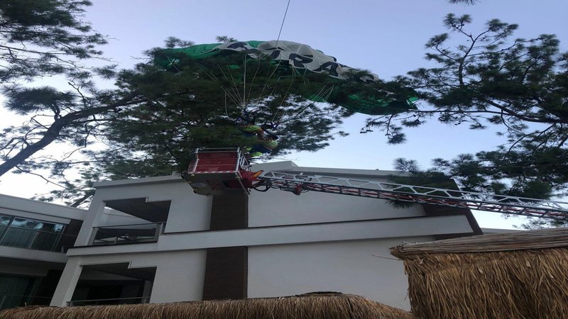 Paraşütün ipi koptu ağaçta takılıp asılı kaldılar